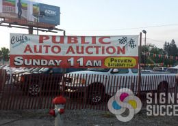 Banner for Cliff's Auto Auction is reused every month, made fast by Signs for Success
