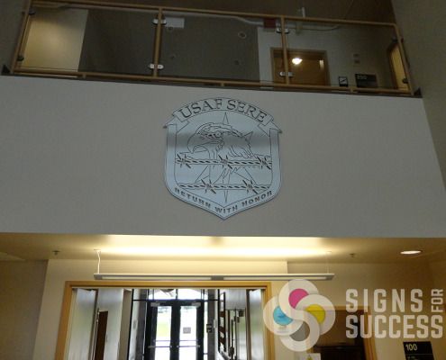 Fairchild Air Force Base wanted a custom metal shield for USAF SERE, Signs for Success helped them get this lobby sign produced and installed fast and reliably