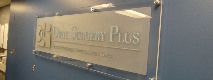 This dimensional lobby sign on clear acrylic looks great mounted with standoffs on the wall, it's a real show piece, by Signs for Success, Spokane for Oral Surgery Plus, office signs, stand-off mounts, lobby signs spokane