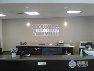 Brushed Aluminum Logo Sign matches custom ADA signs throughout spokane office